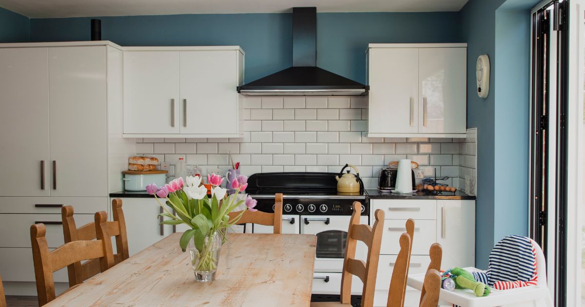 Bright condo kitchen and dining area with light cabinetry, subway tile, and a family dining table, representing buying a condo with a VA loan in San Diego